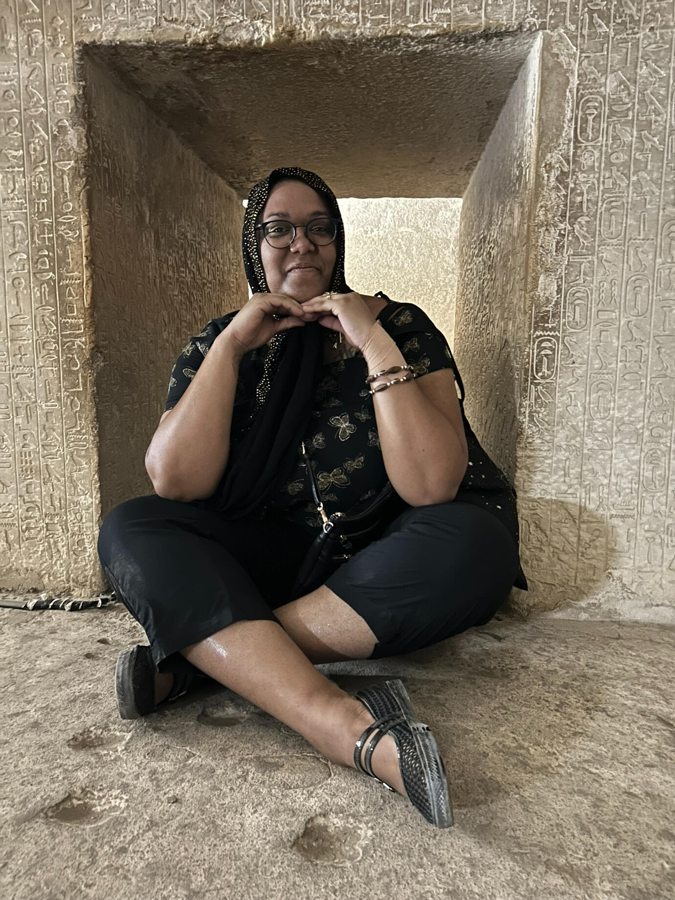Lily Bennu sitting in an underground chamber in Egypt.