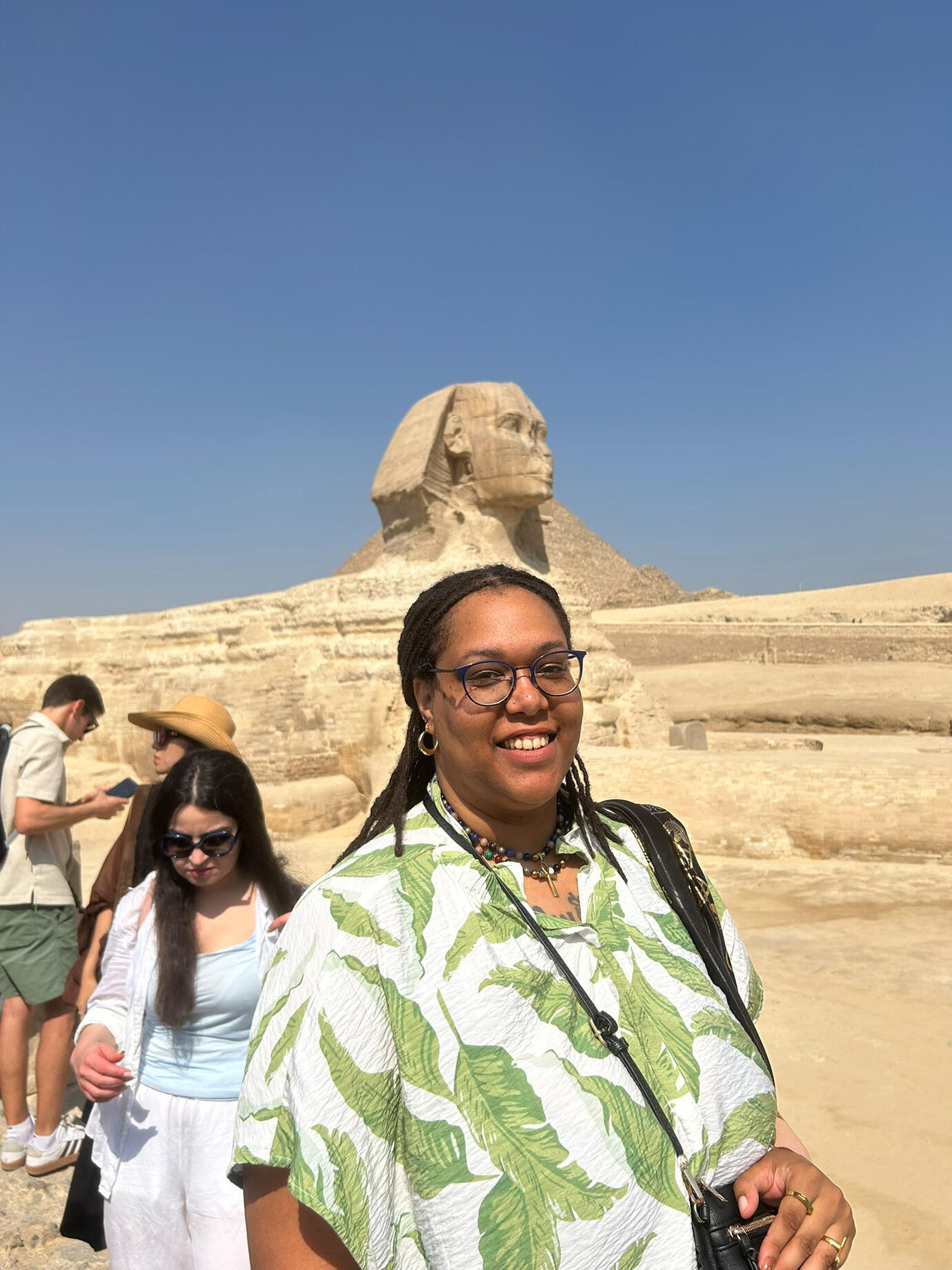 Lily Bennu smiling, standing in front of the Sphinx in Egypt